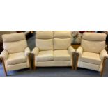 A Modern wooden framed cream leather three piece suite, two seater sofa, arm chairs and electric