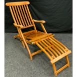 A modern teak garden slatted lounger.