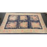 A French woolwork tapestry rug, with panels of flowers on a blue ground, 266cm x 169cm.