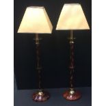 Lighting - a pair of tall brass and lacquered side lights, 74cm high; a turned oak lamp base, (3)