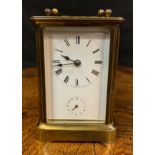 An early 20th century brass carriage clock, Roman numerals, subsidiary seconds dial, bevelled glass,