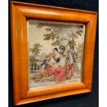 A Victorian woolwork, embroidered with a courtship, 41cm x 38cm, deep cushioned satinwood frame, c.