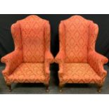 A pair of early to mid 20th century wing back arm chairs, upholstered in red and cream, 123cm