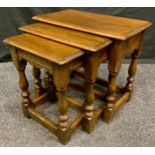 A nest of Jaycee type oak tables, baluster columns, the largest 43cm high, 48cm wide.