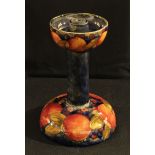 A Moorcroft Pomegranate pattern candlestick21cm high, impressed mark, paper label (faults)