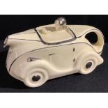 A Sadlers pottery "racing car" teapot, in white glaze with silver lustre borders, 22cm long, C.1930