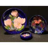 A Moorcroft Magnolia pattern plate, 26cm, impressed marks; an Anemone pattern plate, 19cm
