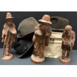 A German Black Forest carved figure, of an elderly gentleman; others; a tin hat box; three trilbies