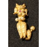 A 14k gold novelty poodle brooch, with ruby chip eyes and seed pearl collar, 3.5cm, 6.7g