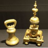 A brass bell shaped weight, to weigh 1000 sovereigns, 24cm; a 19th brass fire dog, 41.5cm (2)