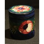 A Moorcroft cylindrical jar and cover, Anemone pattern, decorated with pink and purple flowers on