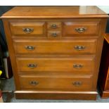 An Arts and Crafts style oak tall chest of drawers, having a pair of short drawers flanking two