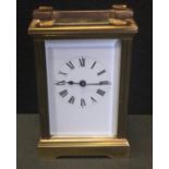 An early 20th century brass carriage timepiece, white dial, black Roman numerals, bevelled glass