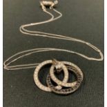 A black and white diamond triple ring pendant necklace, 9ct white gold mount, white metal chain,