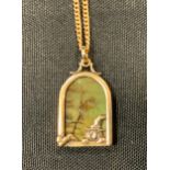 An unusual multi tone stone, possibly agate, pendant as a leprachaun climbing through a window,