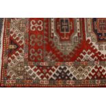 A Middle Eastern woollen rug, the centre with three navette shaped reserves, in blue, cream and