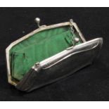 A George V silver evening purse, hinged cover, green silk lined interior, embossed to the angles