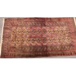 A Middle Eastern woollen rug, the field with 24 guls on a shaded crimson ground, 232cm x 125cm