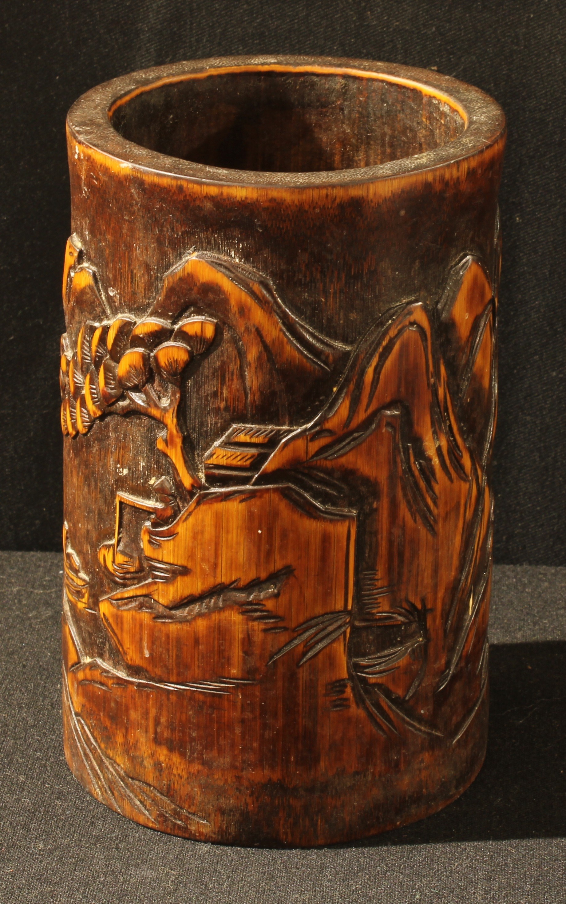 A Chinese bamboo bitong brush pot, carved in relief with a monumental landscape, 17.5cm high