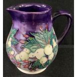 A contemporary Moorcroft ovoid jug, tube lined with pink flowers, berries and foliage on a purple