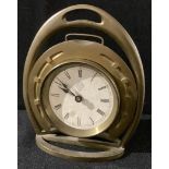 An early 20th century brass novelty equestrian desk timepiece, as a horseshoe within a stirrup,