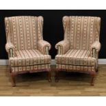 A pair of early 20th century wingback armchairs, stuffed-over upholstery, squab cushion, cabriole