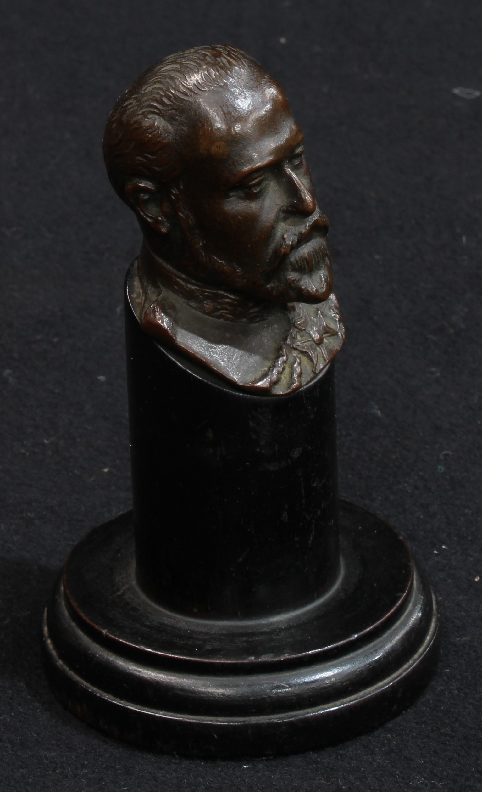 An early 20th century brown patinated bronze desk bust, King Edward VII, ebonised plinth, 14cm high