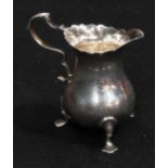 A Victorian silver cream jug, of George II design, wavy rim, acanthus capped double-scroll handle,