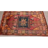 An unusual Middle Eastern woollen rug, the central indigo rectangular field with stylised gul on a