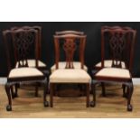 A set of four Chippendale Revival mahogany dining chairs, each with a shaped and pierced splat,