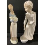 A Lladro figure, girl holding a lamb, 27cm high; a Nao by Lladro figure, bedtime foot bath, 29cm