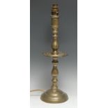 A 19th century Indian/Middle Eastern brass candlestick, knopped pillar, shaped dip pan, domed