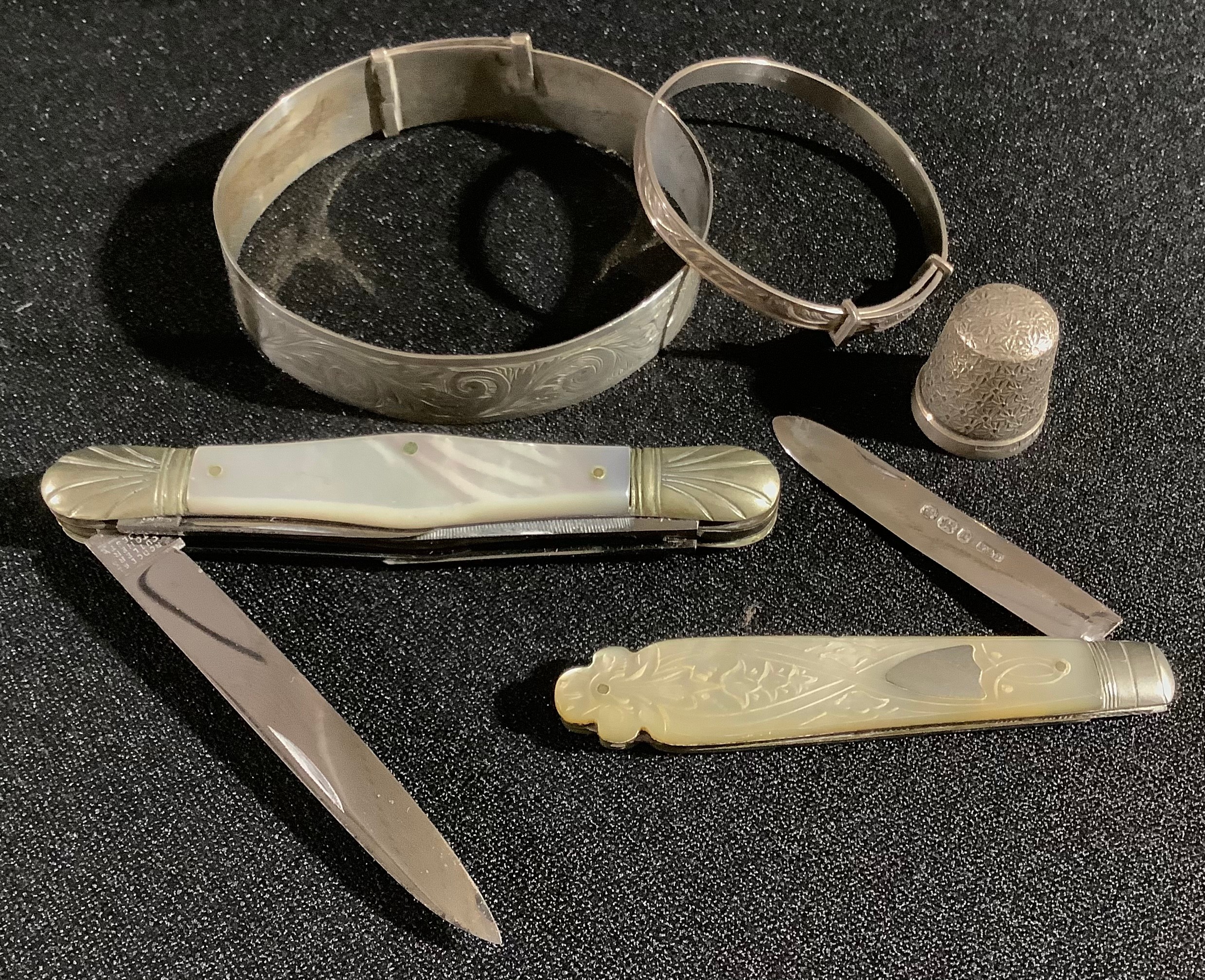 A silver and mother-of-pearl fruit knife; a pen knife; a silver thimble; silver bangles; etc