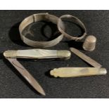 A silver and mother-of-pearl fruit knife; a pen knife; a silver thimble; silver bangles; etc