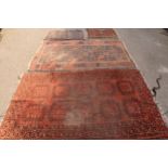 A Middle Eastern rug, with 10 gulss within a gepmetrical border, in tones of red adn brown, 180cm