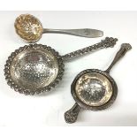 A Swedish silver tea strainer; a silver tea strainer, formed from Middle Eastern coins; an Edwardian