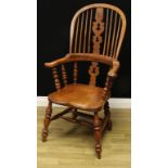 An ash and elm Windsor elbow chair, hoop back, shaped Christmas tree splat, bowed mid rail