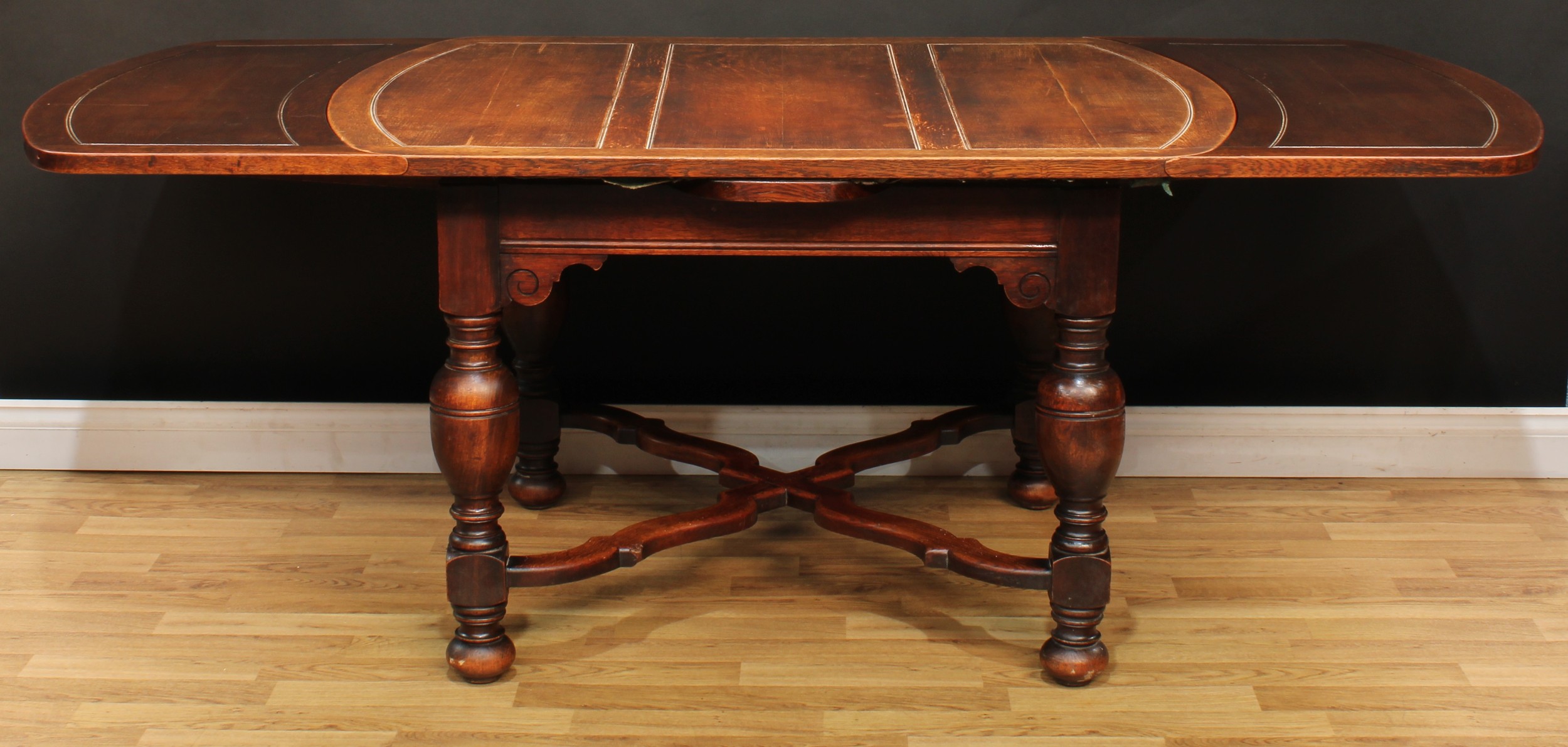 An early 20th century oak draw-leaf dining table, 76cm high, 129cm opening to 213cm long, 99cm wide