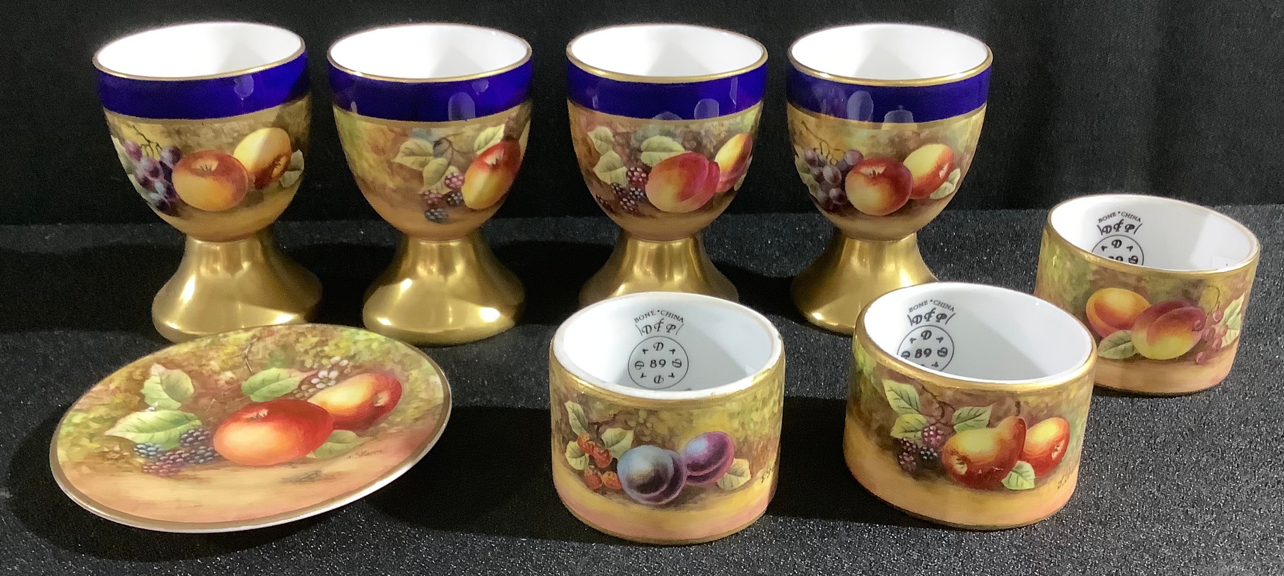 A set of four Durley Porcelain egg cups, by James Skerrett, signed, painted with ripe peaches and