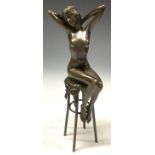 A bronze model of a female nude seated on a high stool, 26cm, 20th century