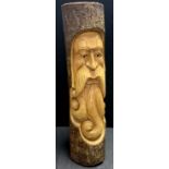 A carved wooden trunk section, applied with a Green Man type bearded gent in relief, 49cm