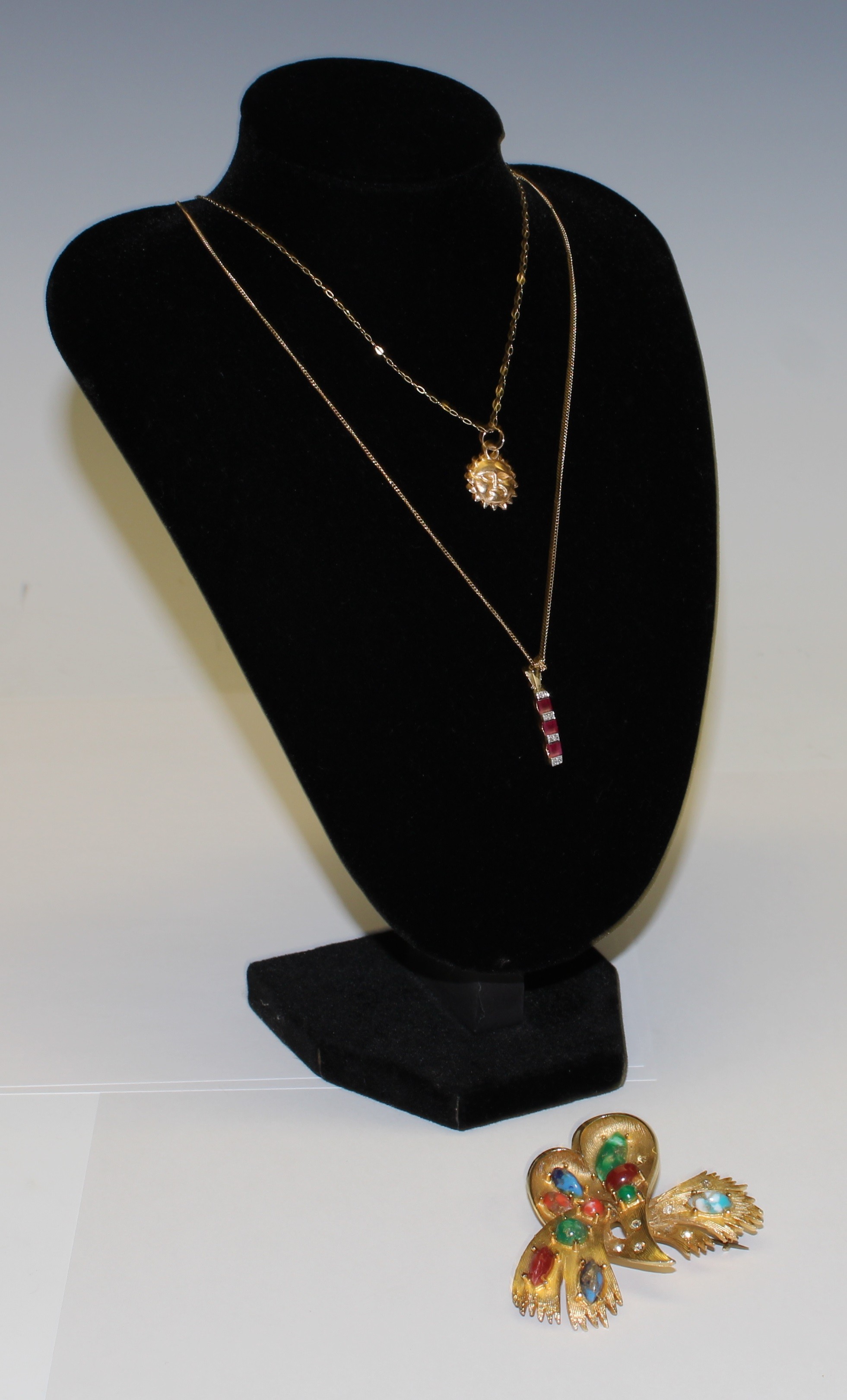 A 9ct gold diamond chip and ruby pendant on a 9ct gold necklace chain, marked 375, a 9ct gold