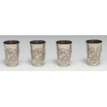 A set of four Chinese silver plated tapered cylindrical beakers, each in relief with a ferocious