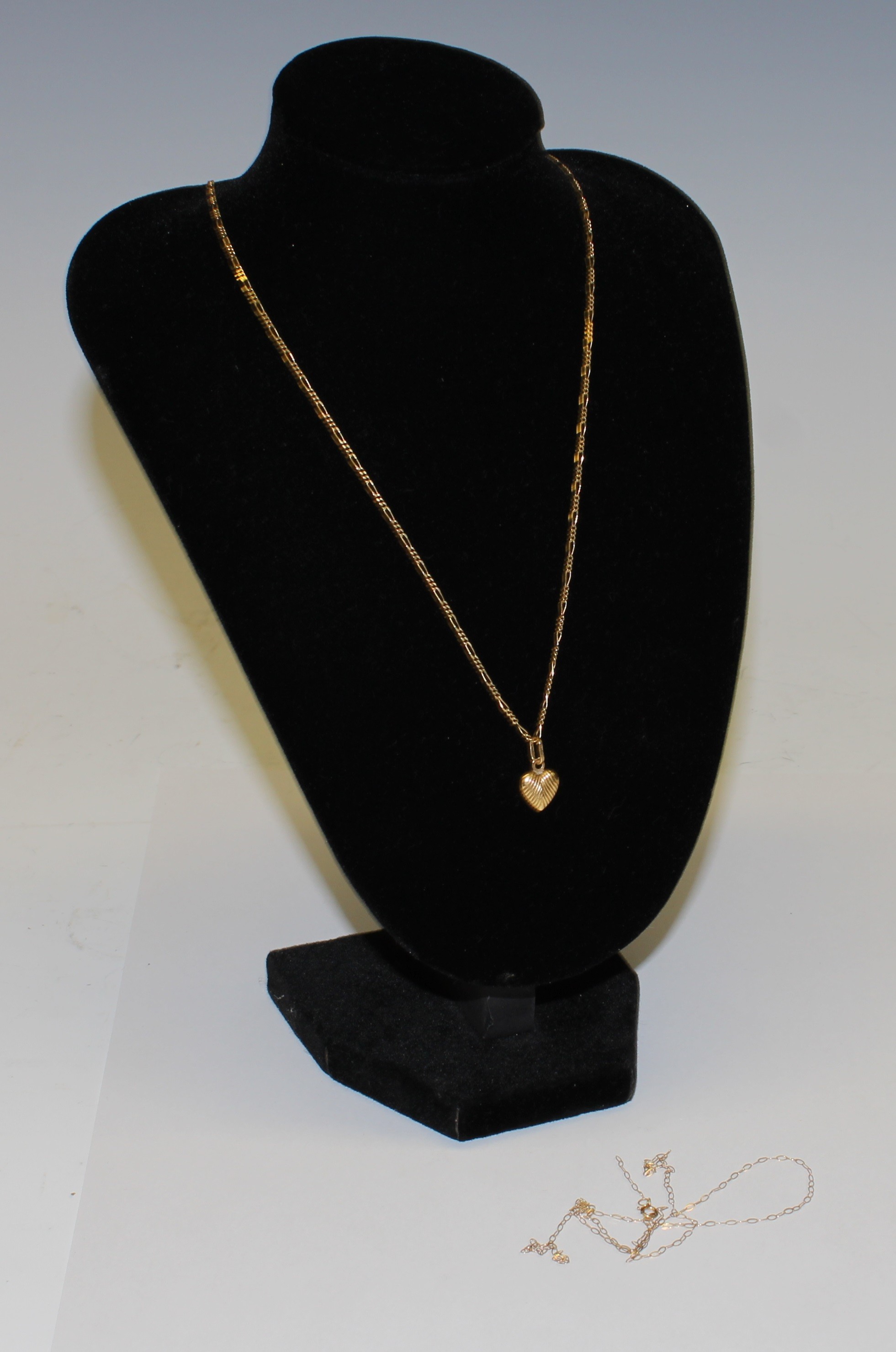 An 18ct gold love heart pendant and chain, marked 750, 3.7g; a broken 9ct gold chain, 0.3g