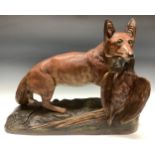 A French terracotta model of a red fox with prey gripped in its mouth, glass eyes, 58cm wide, 48cm