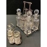 A late Victorian silver plated and cut glass six bottle cruet stand, tri-form handle; another