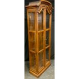 A 20th century Drexel Heritage oak narrow display cabinet, arched top above a pair of glazed doors