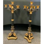A pair of modern bronzed and gilt metal six light five branch table candlesticks, in the Regency