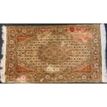 A Middle Eastern silk rug, the field with small scrolling flowerheads, banded border, in tones of