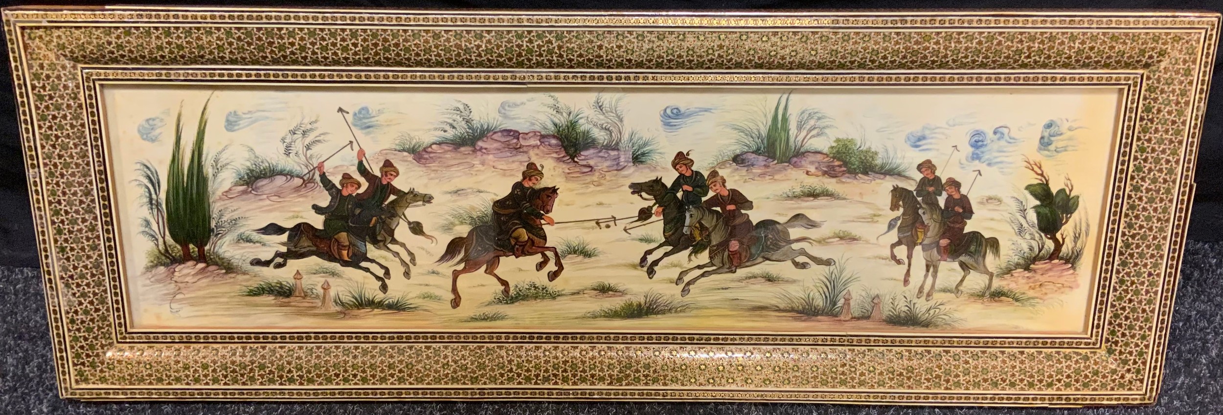 A Middle Eastern painting on Plaque, 'A Clash of Horsemen', indistinctly signed, 17cm x 63cm; in a